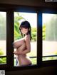 A naked woman standing in front of a window.