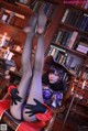 A woman sitting in a chair in front of a bookshelf.